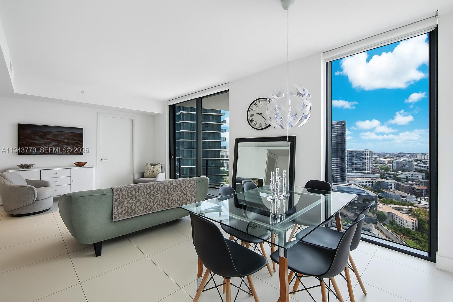 A modern living and dining area features floor-to-ceiling windows with expansive city views — 501 NE 31st St # 3009, Miami FL 33137, MIAMI, FL