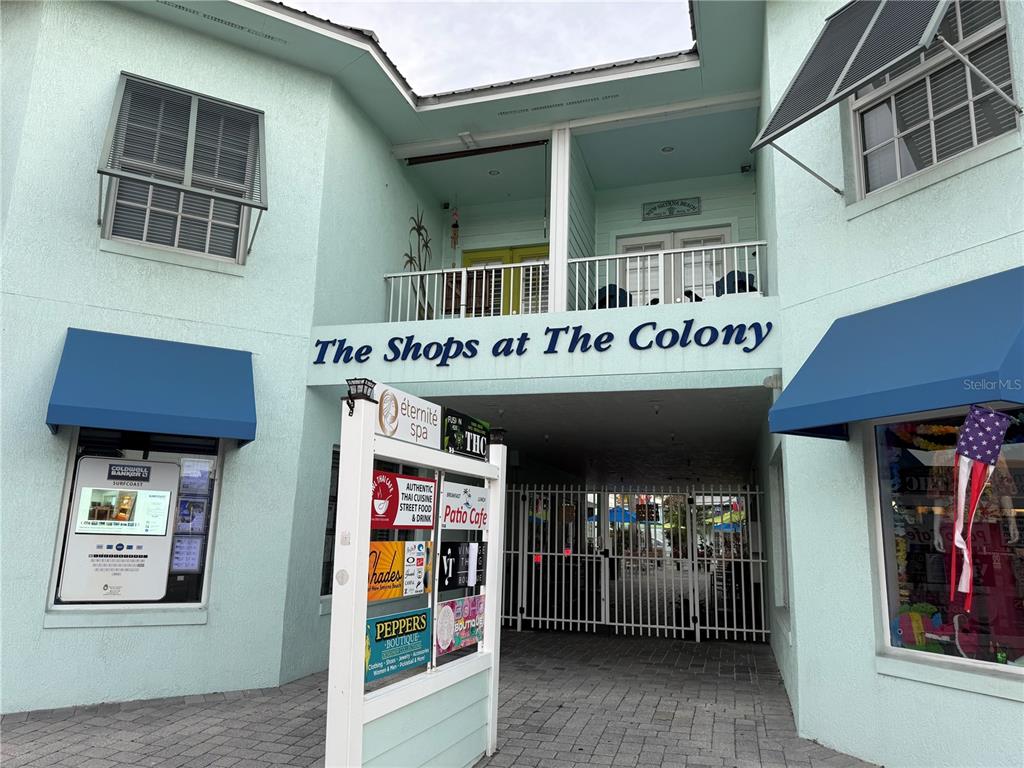 The exterior of a light blue commercial building features a sign for The Shops at The Colony — 362 FLAGLER AVENUE, NEW SMYRNA BEACH, FL