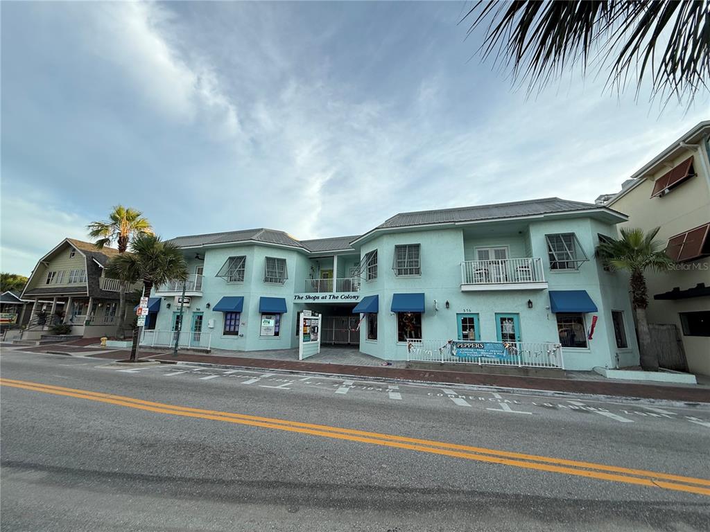 A two-story light blue commercial building with blue awnings sits along a paved street — 362 FLAGLER AVENUE, NEW SMYRNA BEACH, FL