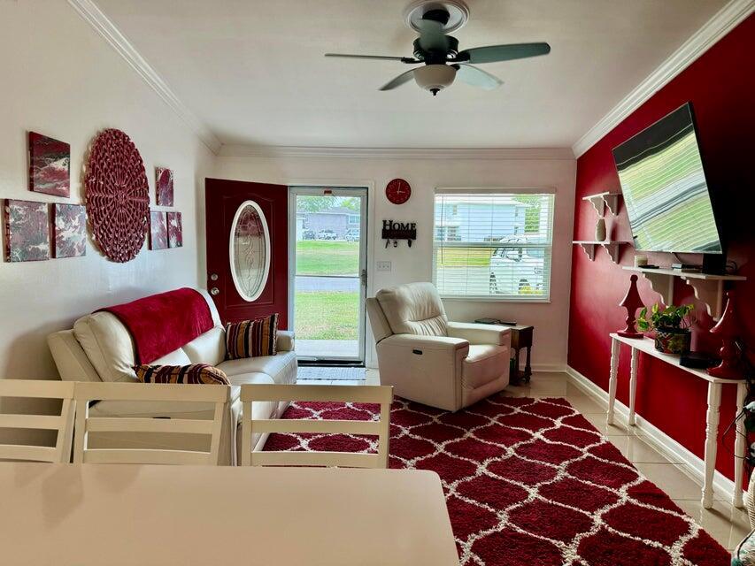 A living room features a white sofa, a recliner, a red rug, and a red accent wall — 5248 SE 43rd Trace, Okeechobee FL 34974, OKEECHOBEE, FL