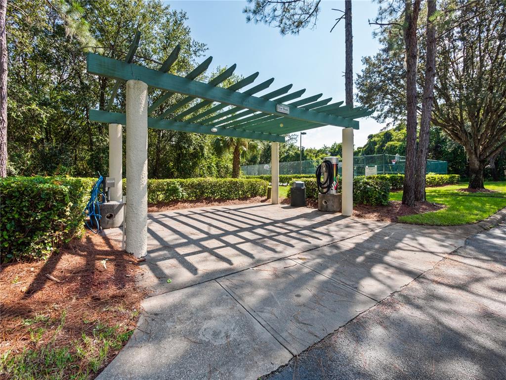 An outdoor car wash station features a green pergola structure with concrete pillars — 8904 LEGACY COURT UNIT 110, KISSIMMEE, FL