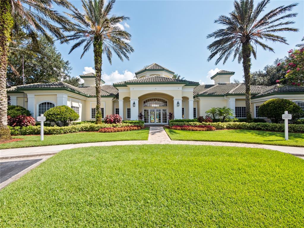 A single-story building with a tiled roof, palm trees, and a landscaped front lawn — 8904 LEGACY COURT UNIT 110, KISSIMMEE, FL