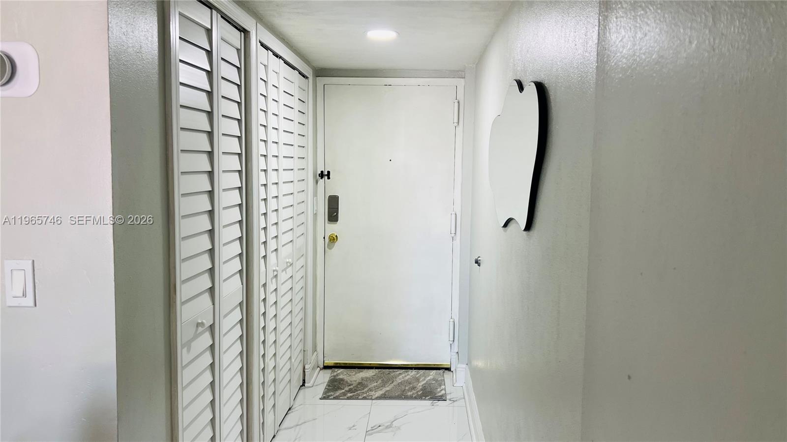 An entryway features a white door, louvered closet doors, and light-colored tile flooring — 14250 SW 62nd St # 319, Miami FL 33183, MIAMI, FL