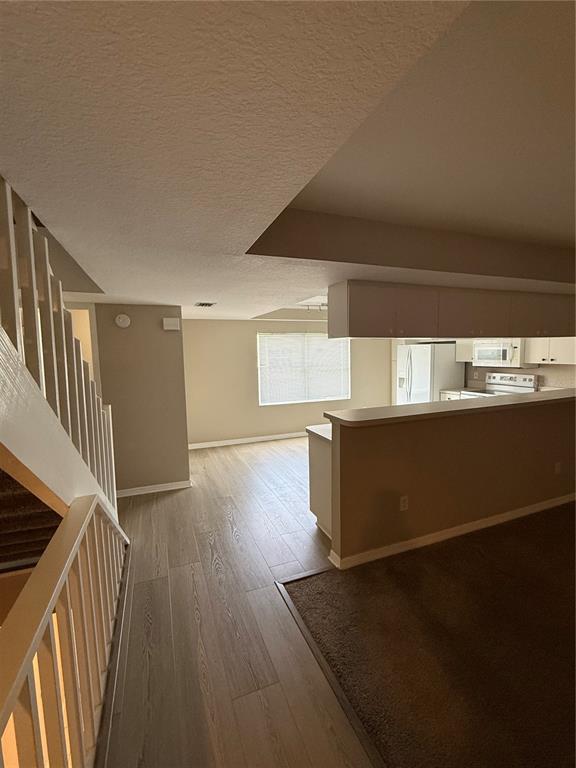A view from a staircase looking toward a kitchen with a breakfast bar and dining area — 1117 PINELLAS BAYWAY S UNIT 303, TIERRA VERDE, FL