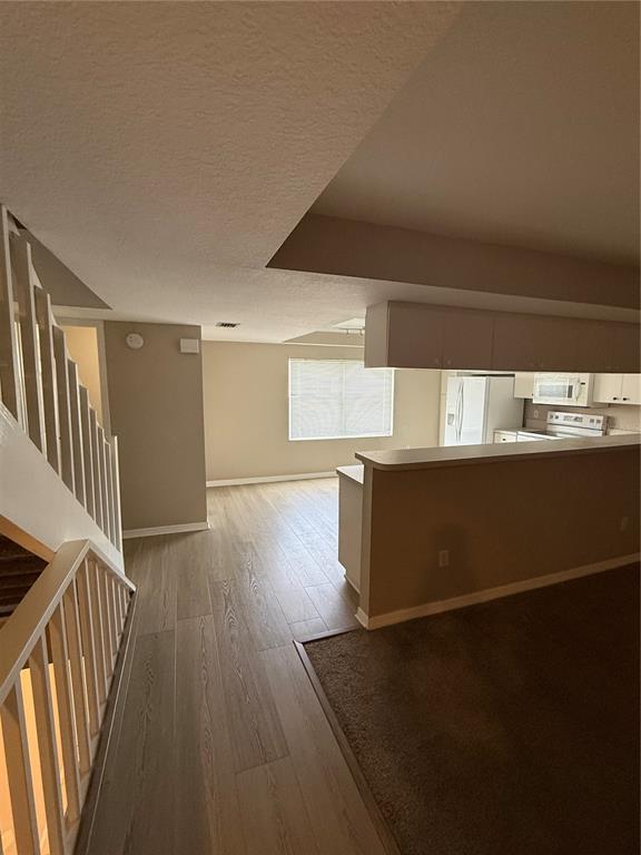 A view from a staircase looking toward a kitchen with a breakfast bar and dining area — 1117 PINELLAS BAYWAY S UNIT 303, TIERRA VERDE, FL