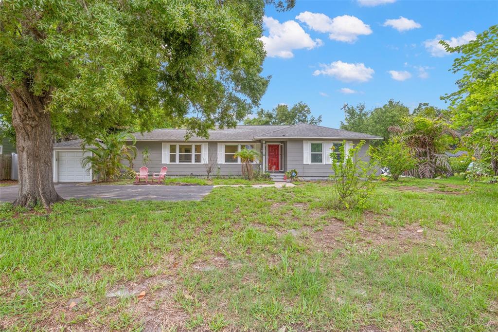 A single-story gray house with a red front door and an attached garage sits outdoors — 3822 W EUCLID AVENUE, TAMPA, FL
