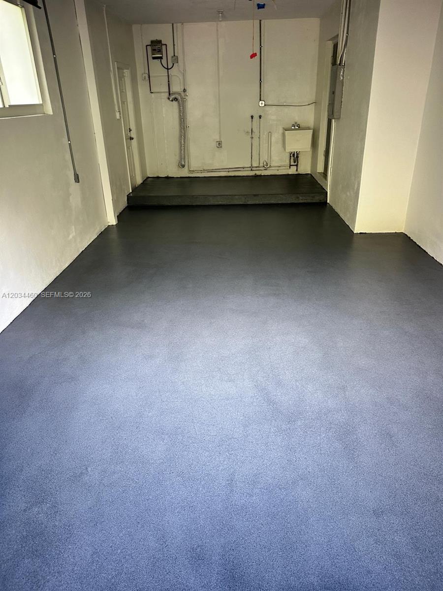 This garage features a gray epoxy floor, a raised rear platform, and utility connections — 400 Miller Rd, Coral Gables FL 33146, CORAL GABLES, FL