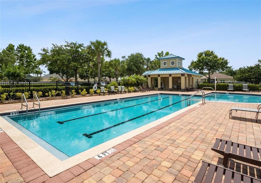 A rectangular swimming pool with a surrounding brick patio and a small clubhouse building — 420 MARATHON LANE, SANFORD, FL
