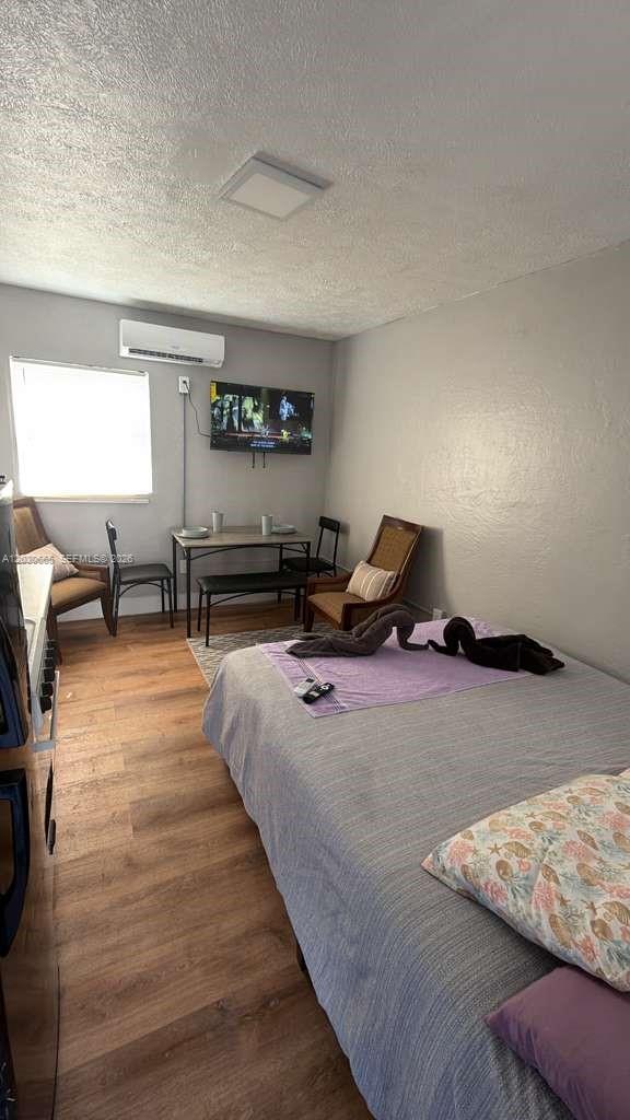 A studio apartment features a bed, a small dining table, and a wall-mounted television — 615 NE 4th St # 3, Hallandale Beach FL 33009, HALLANDALE BEACH, FL