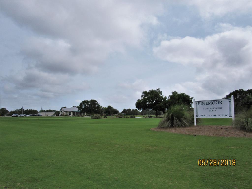 A sign for Pinemoor golf course stands on a grassy lawn near a clubhouse — 274 ROTONDA BOULEVARD W, ROTONDA WEST, FL
