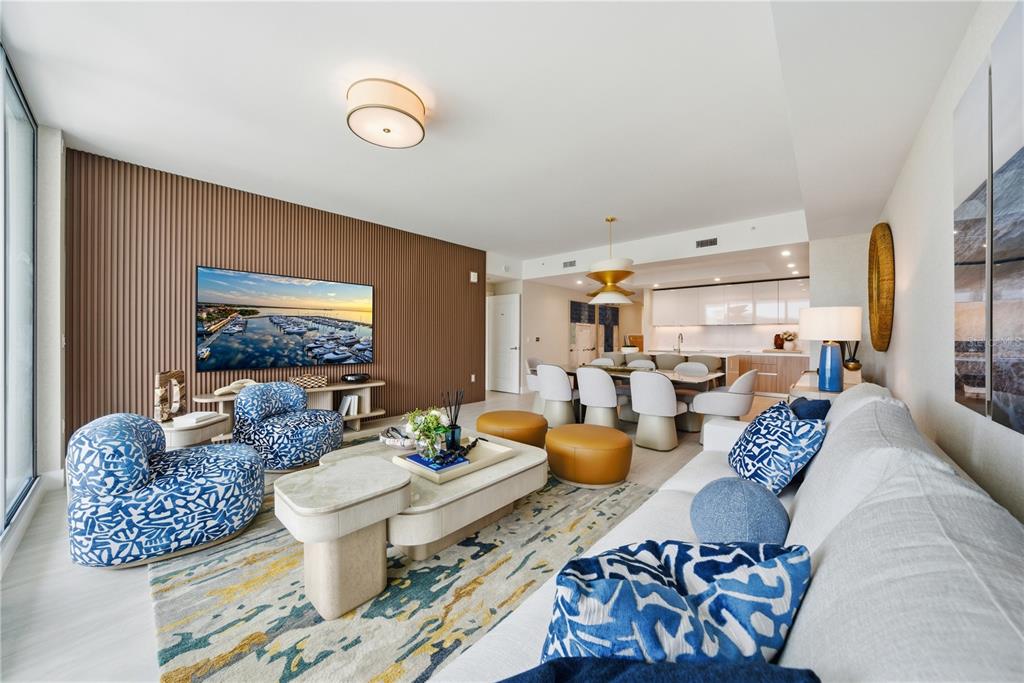 A modern living room features a slatted wood accent wall, blue patterned chairs, and dining area — 5713 BOWEN DANIEL DRIVE UNIT 703, TAMPA, FL
