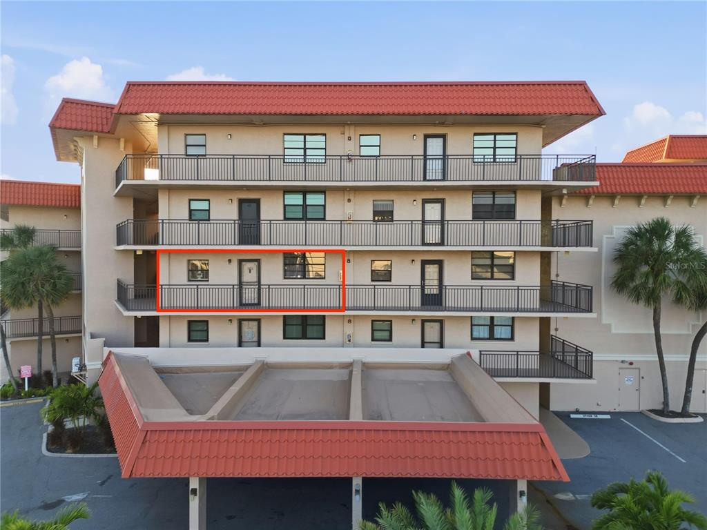 A multi-story apartment building features a red tile roof and a highlighted third-floor balcony — 17580 GULF BOULEVARD UNIT 302, REDINGTON SHORES, FL