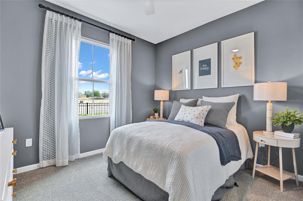 A bedroom features gray walls, a bed with white and blue bedding, and a window — 6390 CLOVER STREET, LAKE HAMILTON, FL