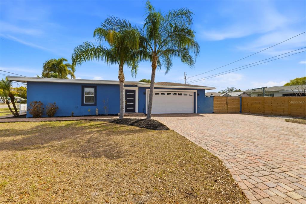 A blue single-story house with a white garage door and two palm trees in front — 3998 22ND AVENUE N, ST PETERSBURG, FL