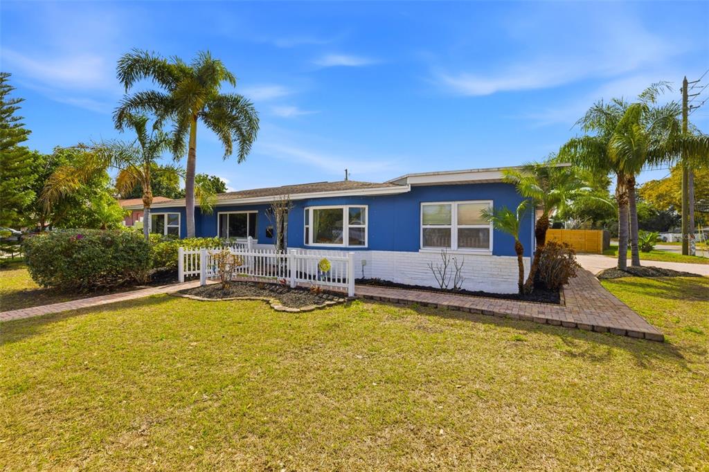 A blue and white single-story house features a front yard, palm trees, and brick walkways — 3998 22ND AVENUE N, ST PETERSBURG, FL