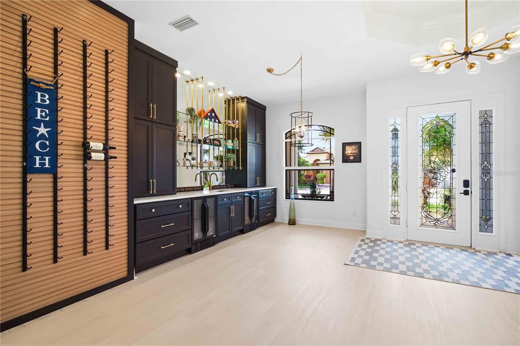A room features a dark wood wet bar, wine rack wall, and a stained glass door — 8051 36TH STREET CIRCLE E, SARASOTA, FL