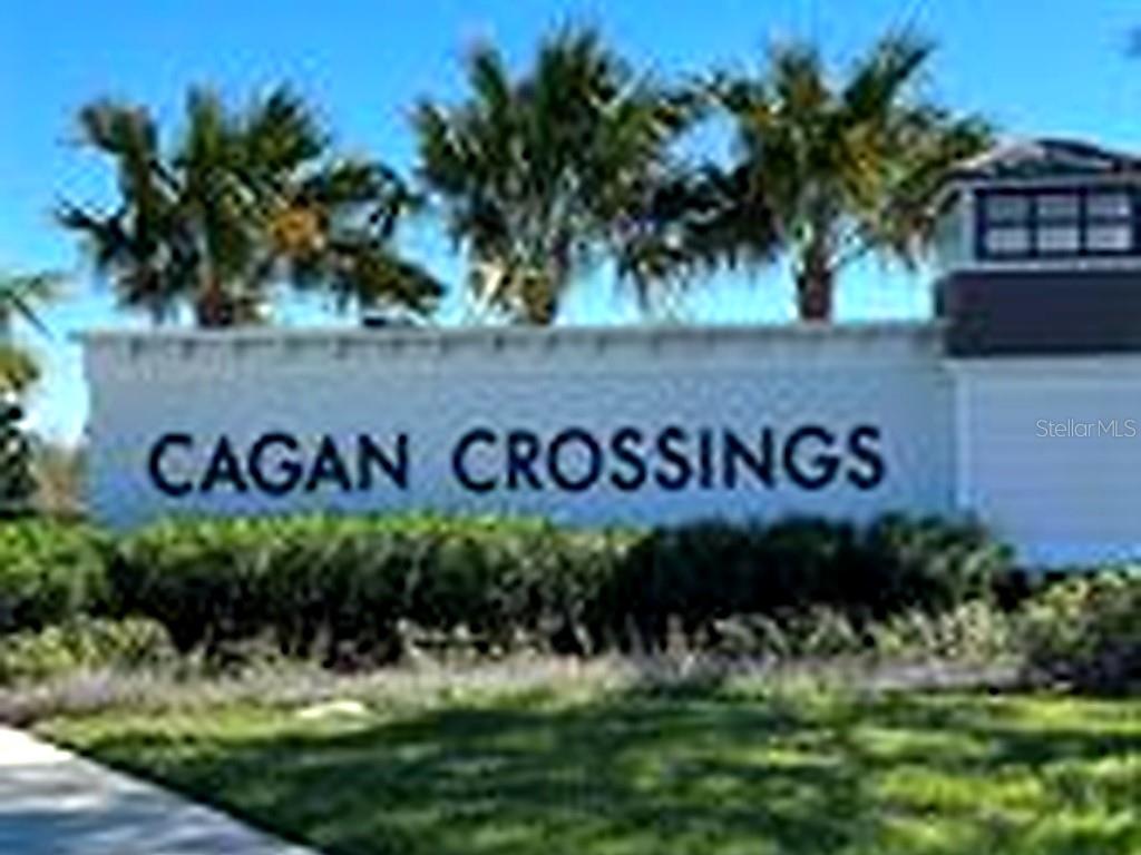 A sign for Cagan Crossings stands in front of palm trees and a building exterior — 953 RIVERS CROSSING STREET, CLERMONT, FL