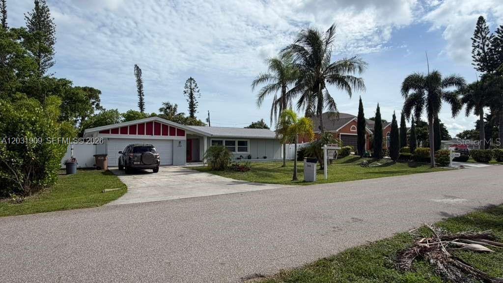 A single-story house with a white exterior, red trim, and a paved driveway — 244 SE 46TH ST, Cape Coral FL 33904, CAPE CORAL, FL