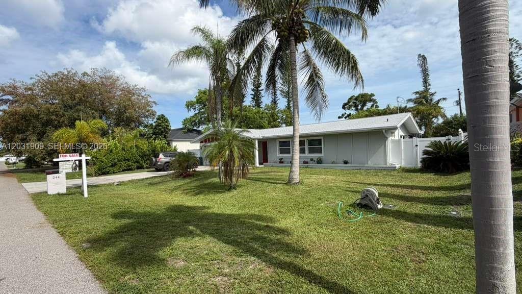 A single-story house with a gray exterior, a palm tree, and a for-sale sign — 244 SE 46TH ST, Cape Coral FL 33904, CAPE CORAL, FL