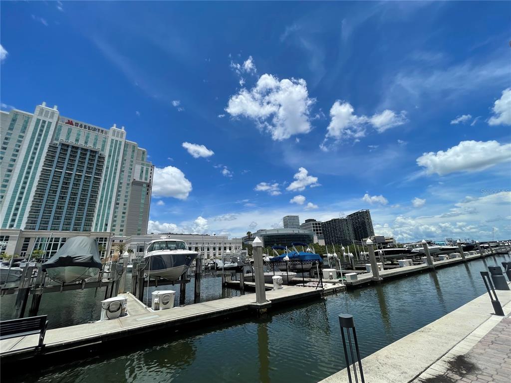 An outdoor dining area overlooks a marina with boats and a large waterfront building — 700 S HARBOUR ISLAND BOULEVARD UNIT 110, TAMPA, FL