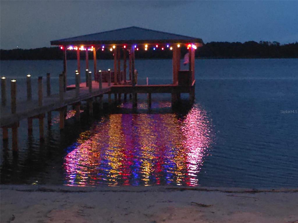 A wooden dock with a covered pavilion extends into a lake at twilight — 6805 BASS HIGHWAY, ST CLOUD, FL