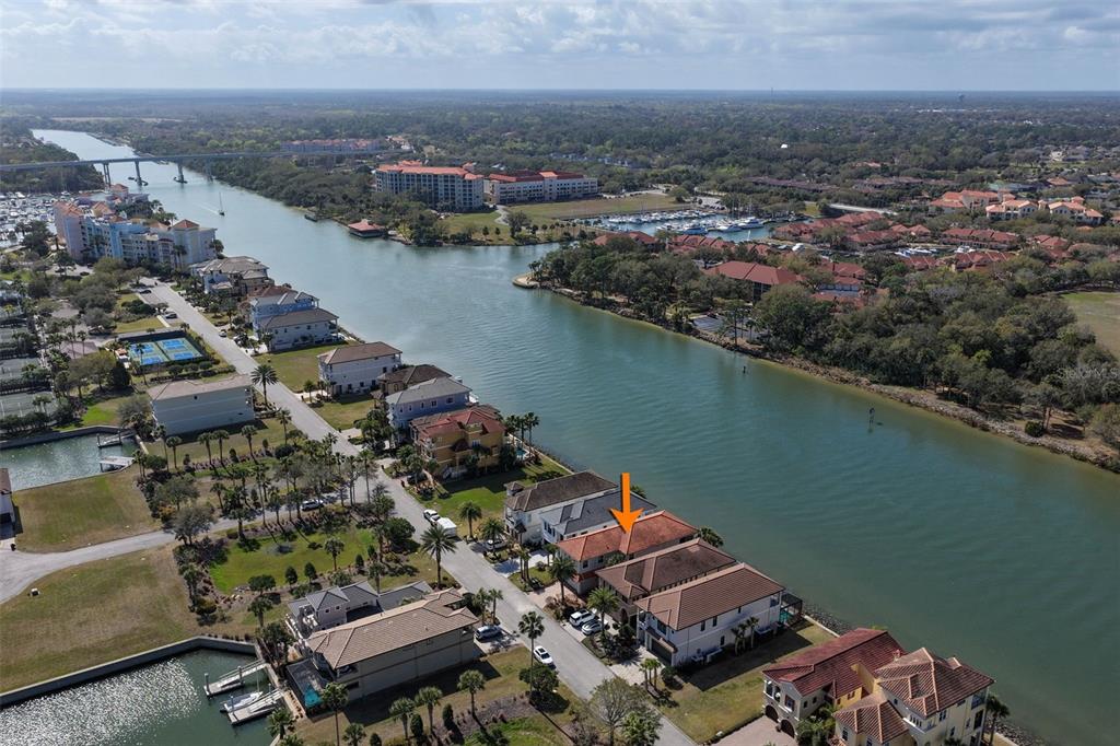 An aerial view shows a waterfront house with a red tile roof and an orange arrow — 262 YACHT HARBOR DRIVE, PALM COAST, FL