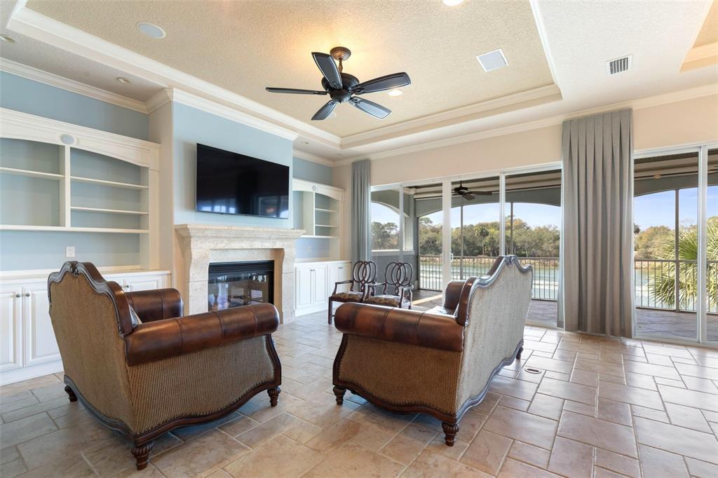 A living room features a fireplace, built-in shelving, leather furniture, and sliding glass doors — 262 YACHT HARBOR DRIVE, PALM COAST, FL