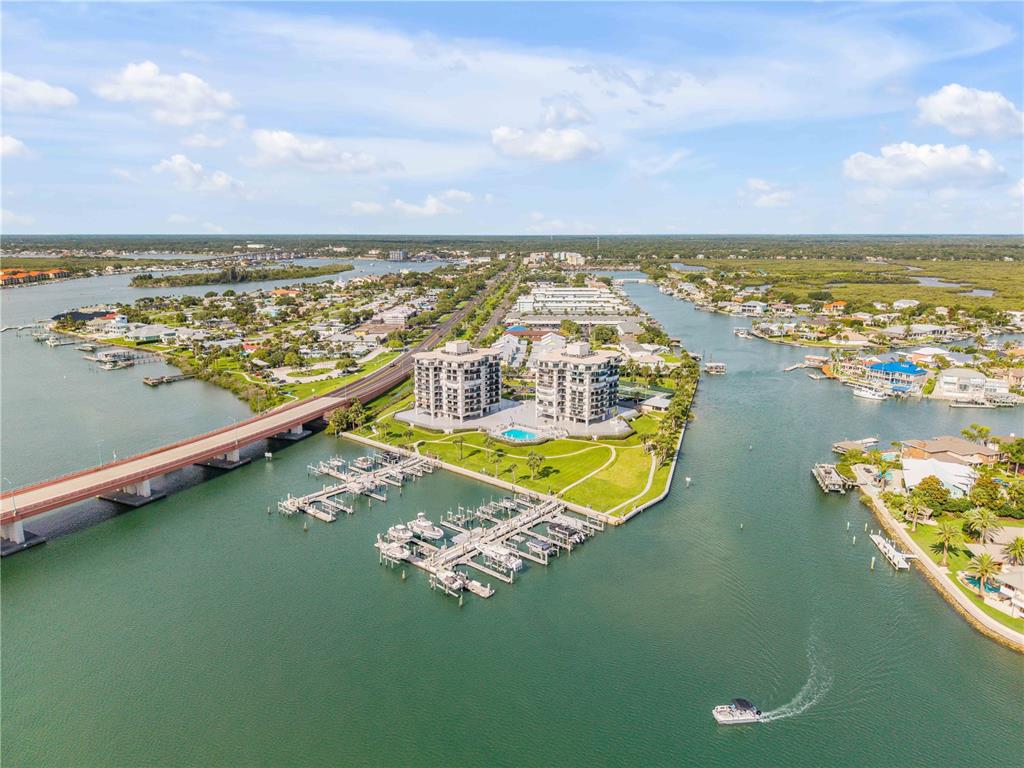 An aerial view shows two waterfront apartment buildings with a marina and a long bridge — 503 N CAUSEWAY UNIT 1020, NEW SMYRNA BEACH, FL