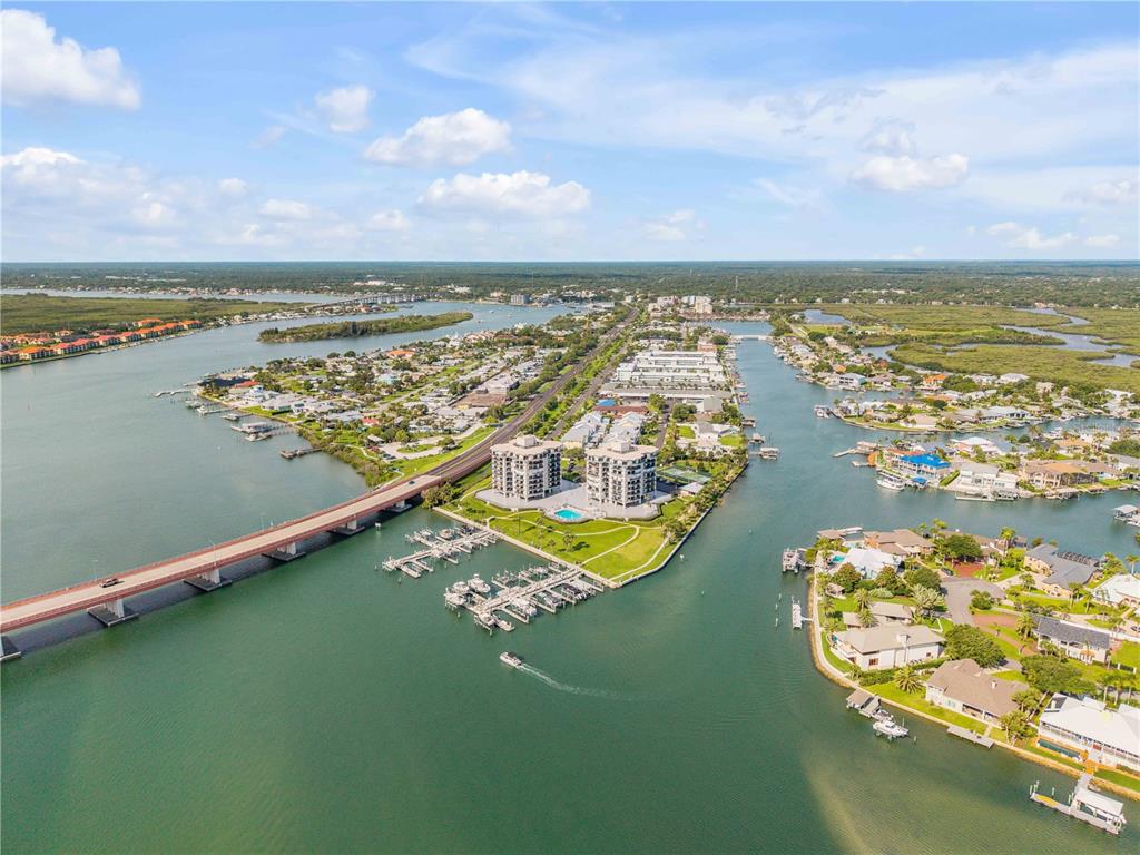 An aerial view of a waterfront condominium complex with a bridge and boat docks — 503 N CAUSEWAY UNIT 1020, NEW SMYRNA BEACH, FL