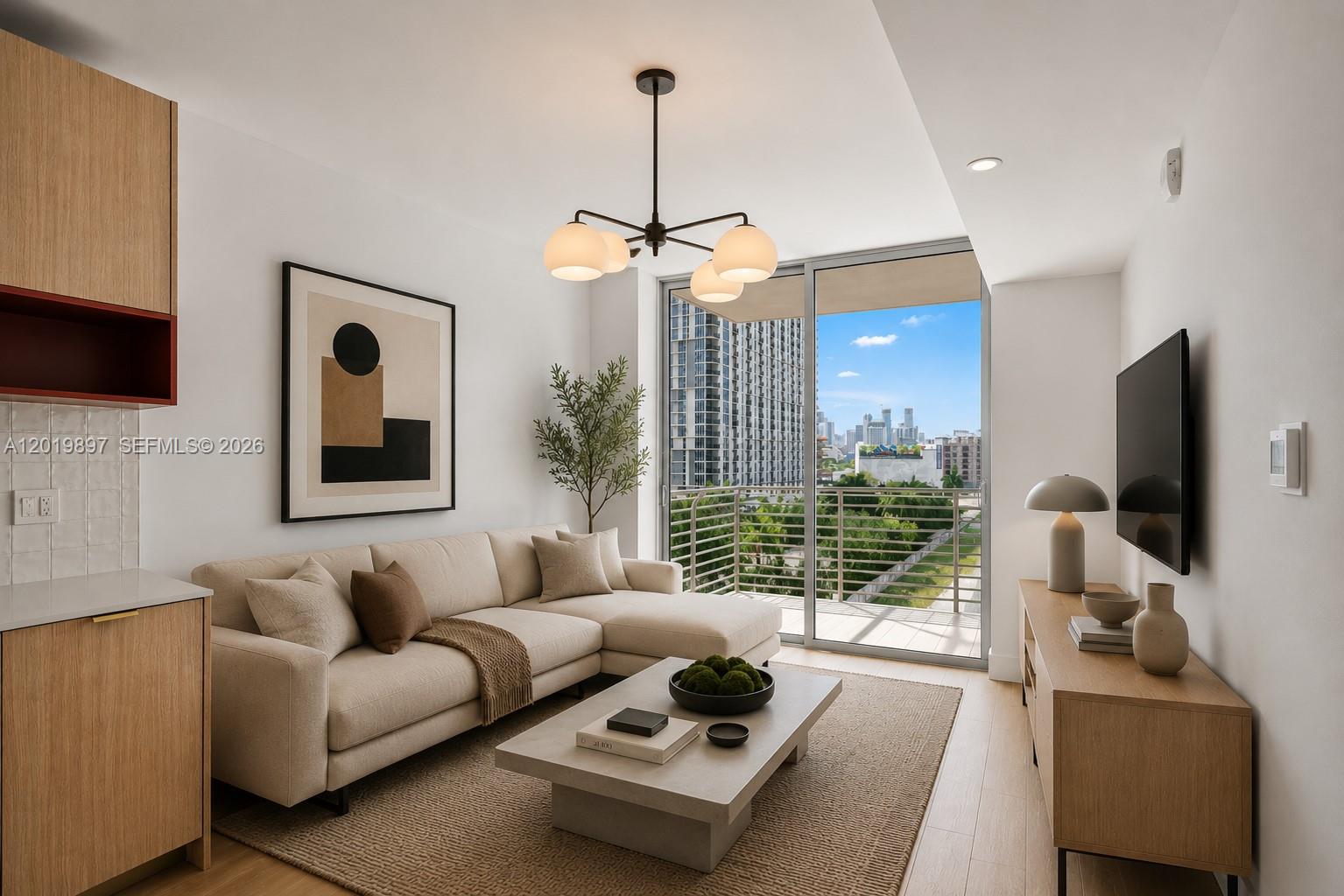 This living room features a beige sectional sofa, a coffee table, and a balcony view — 90 NE 32nd St # 627, Miami FL 33137, MIAMI, FL