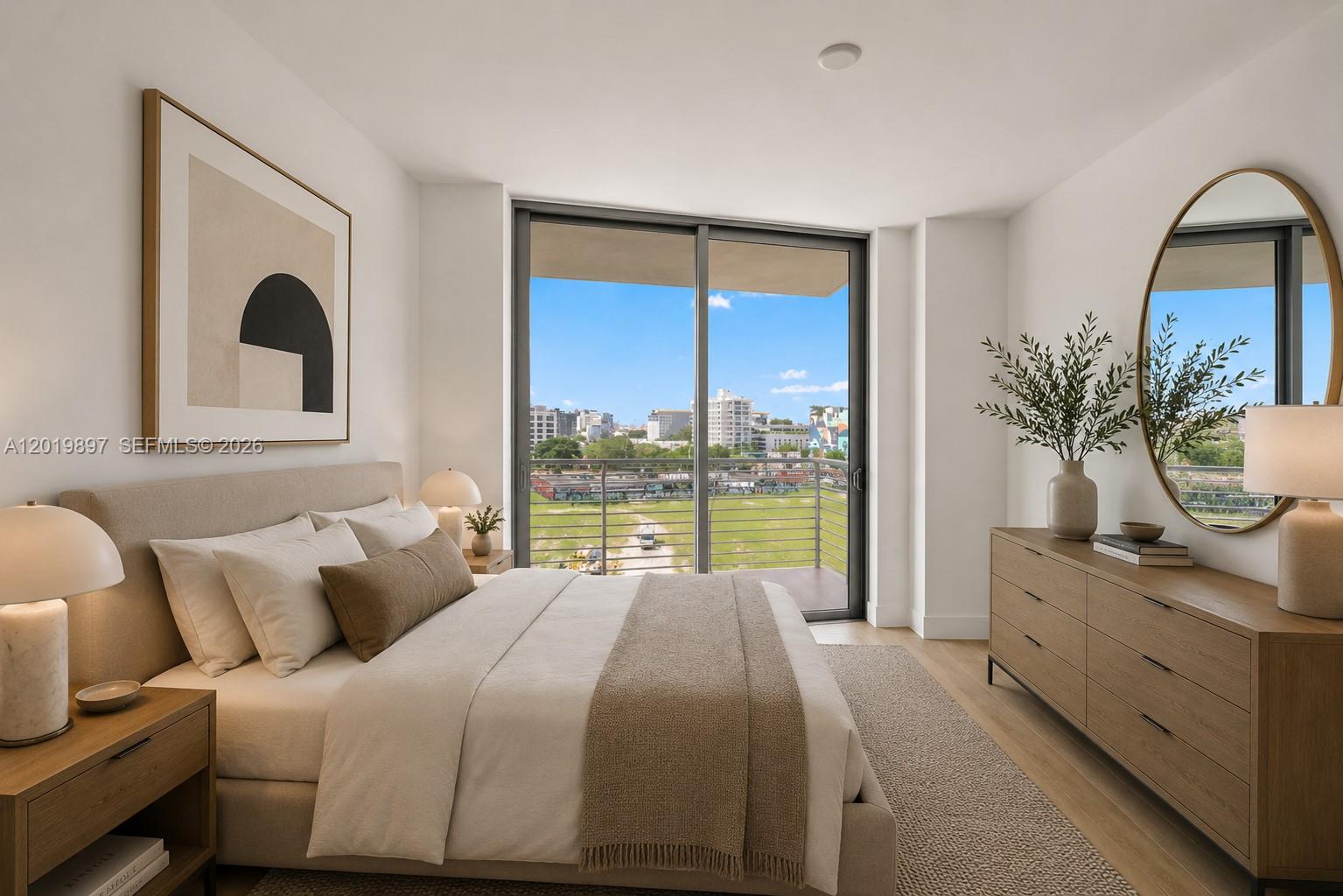 A modern bedroom features a bed, dresser, circular mirror, and a balcony with city views — 90 NE 32nd St # 627, Miami FL 33137, MIAMI, FL