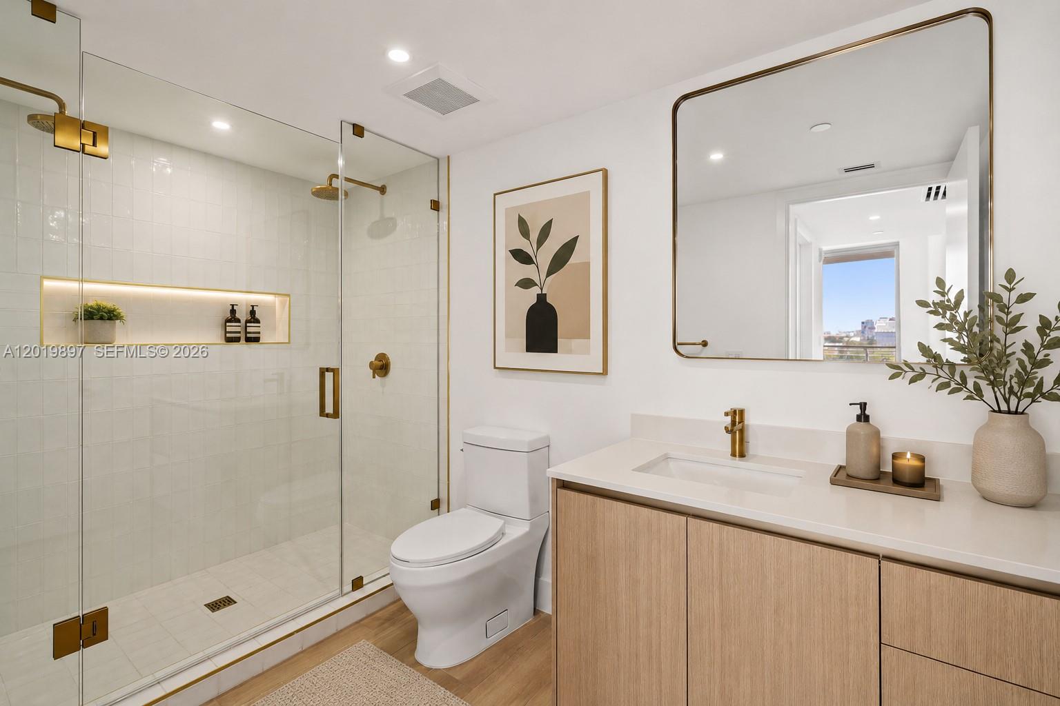 A modern bathroom features a glass-enclosed shower, a white toilet, and a light wood vanity — 90 NE 32nd St # 627, Miami FL 33137, MIAMI, FL