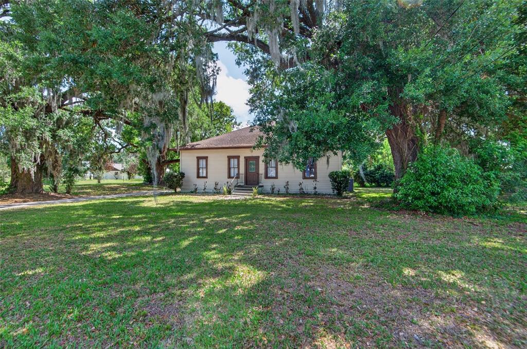 An aerial view shows a house with a large yard, mature trees, and a driveway — 200 N ORANGE AVENUE, FORT MEADE, FL