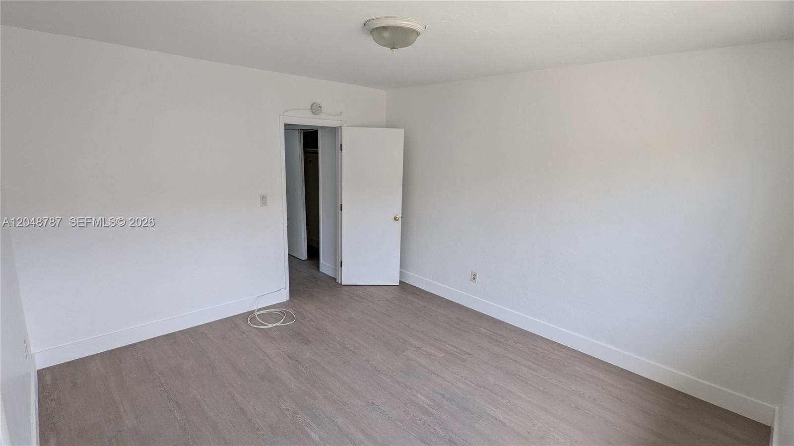 An empty room features white walls, light wood-look flooring, and an open closet door — 811 81st St # 2, Miami Beach FL 33141, MIAMI BEACH, FL