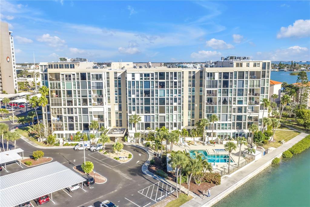 An aerial view of a multi-story apartment building with a pool and parking lot — 7400 SUN ISLAND DRIVE S UNIT 103, SOUTH PASADENA, FL