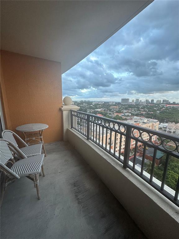A balcony with two chairs and a small table overlooks a city skyline — 3232 CORAL WAY UNIT 1607, MIAMI, FL