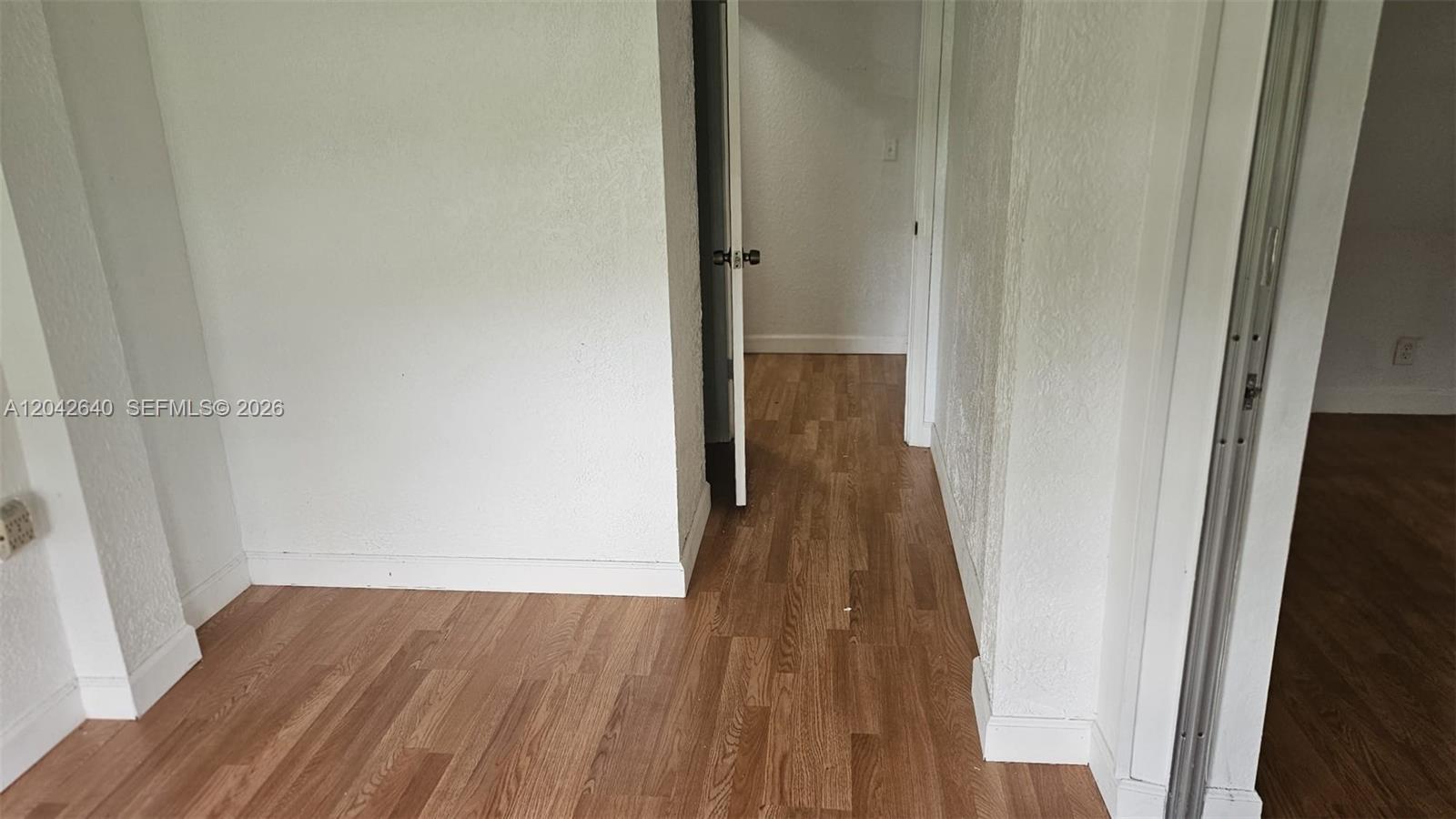 An interior view shows a hallway with light wood-look flooring and white walls — 8555 NW 10th St # B106, Plantation FL 33322, PLANTATION, FL