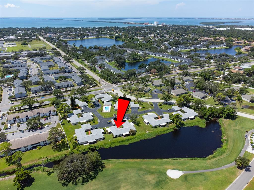 An aerial view shows a single-story residential building with a red arrow pointing to it — 2187 CORINNE COURT S UNIT C, ST PETERSBURG, FL