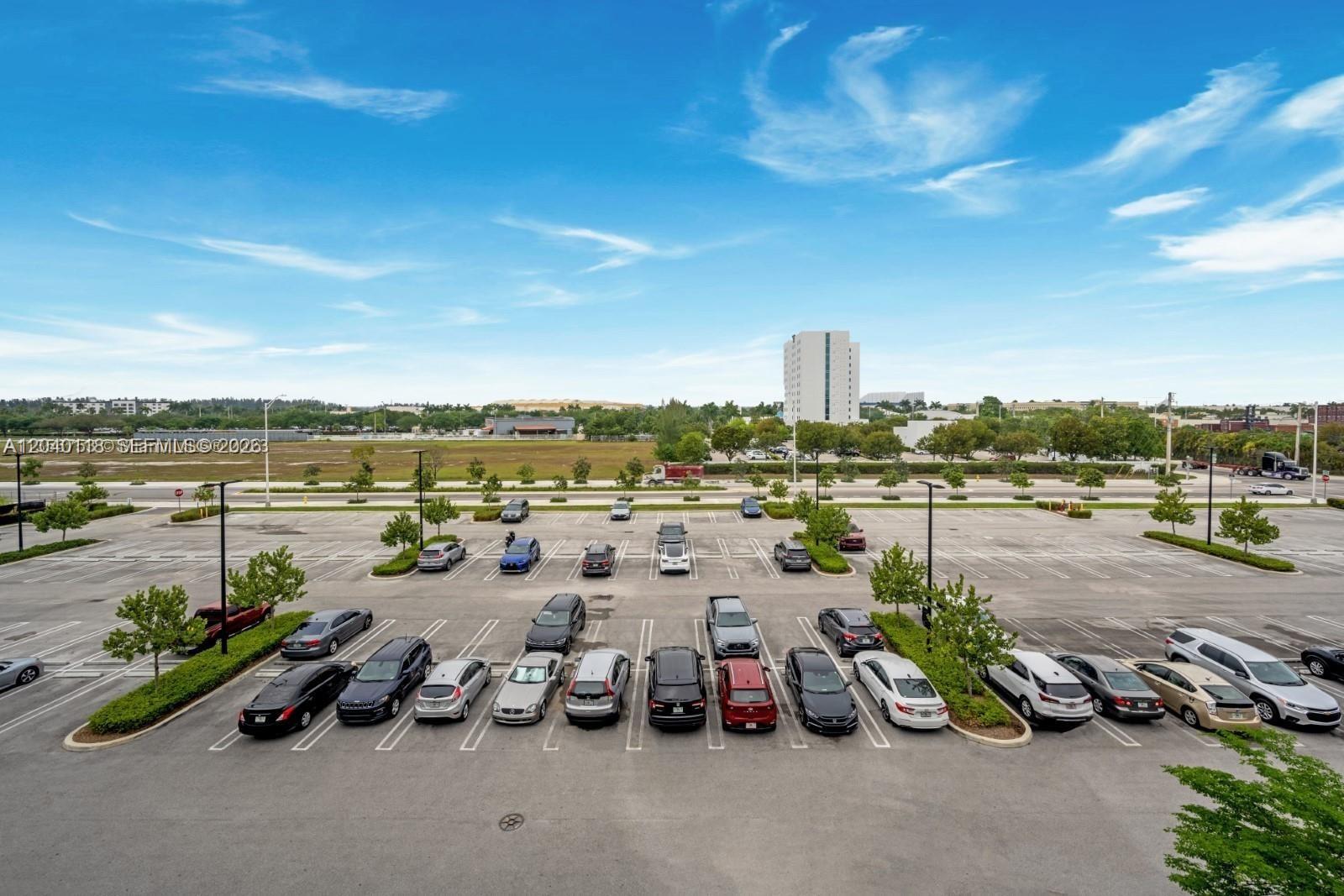 An elevated view of a large parking lot with numerous cars parked in marked spaces — SWEETWATER, FL