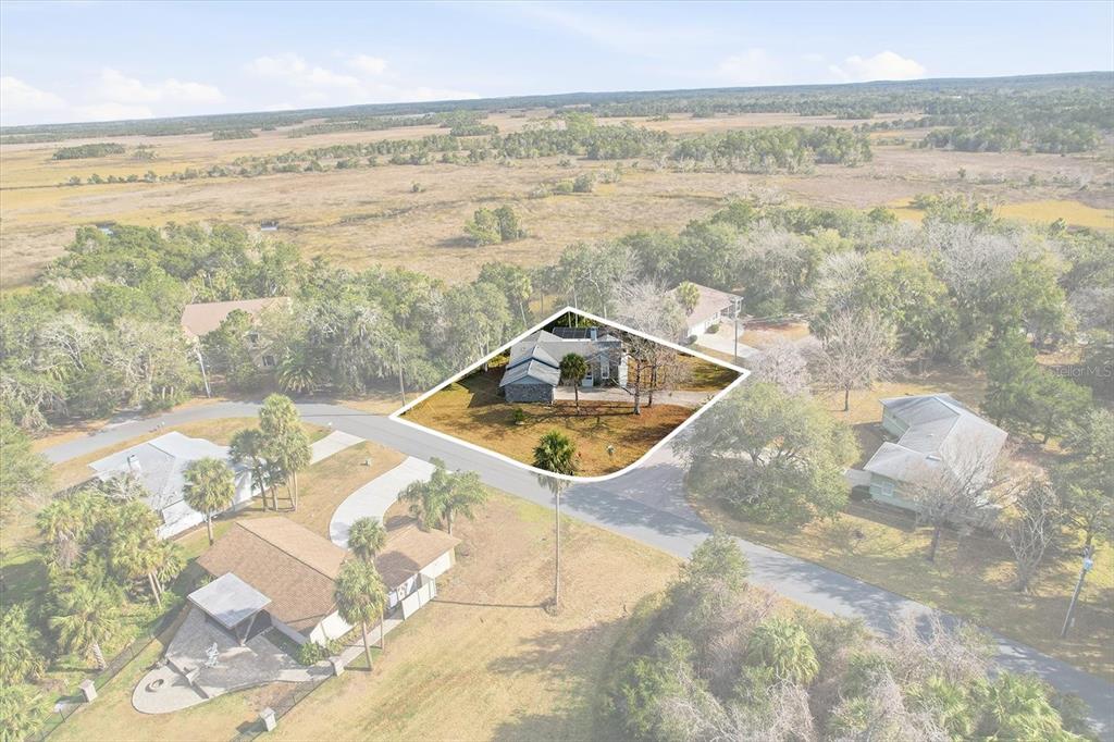 An aerial view shows a house with a highlighted property boundary in a rural setting — 4601 S GATOR LOOP, HOMOSASSA, FL