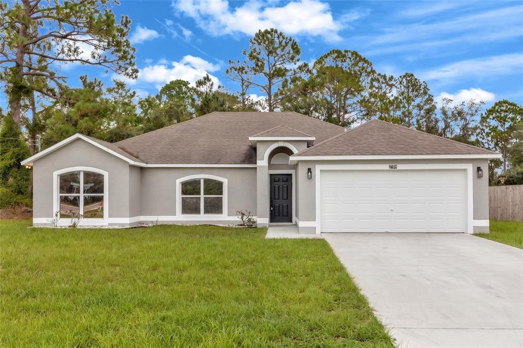 A single-story house with a gray stucco exterior, a two-car garage, and a concrete driveway — 2190 GLENLOCK DRIVE, DELTONA, FL