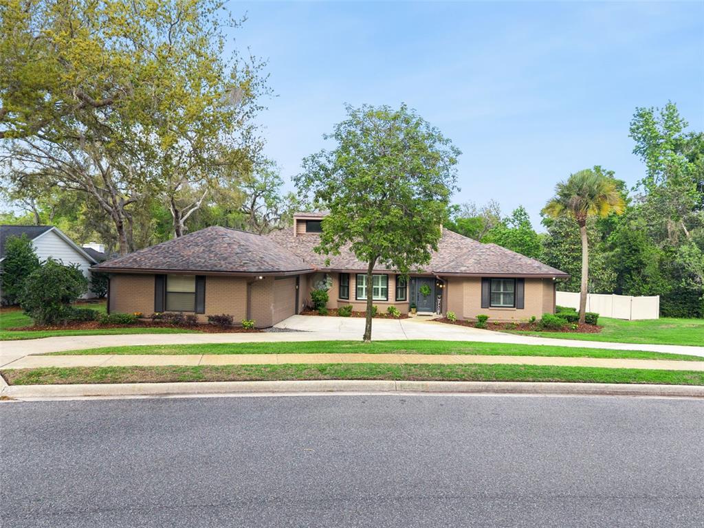 A single-story brick house with a multi-gabled roof and a curved driveway — 441 WILD OAK CIRCLE, LONGWOOD, FL