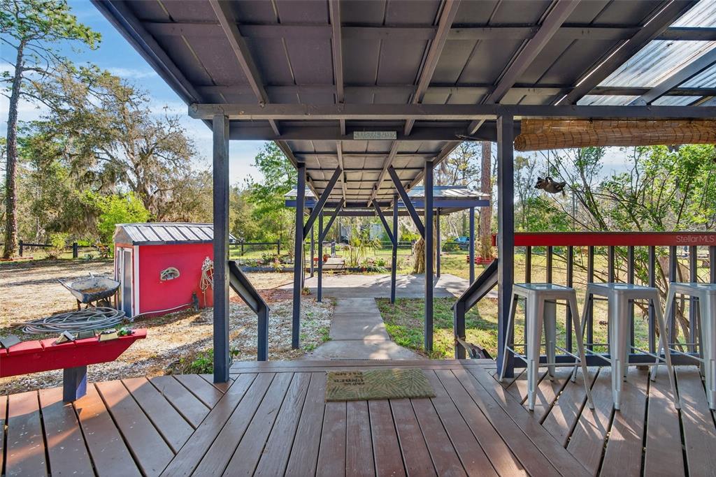 A red two-story house with a covered patio and a detached shed in a yard — 5080 N ALEXA TERRACE, CRYSTAL RIVER, FL
