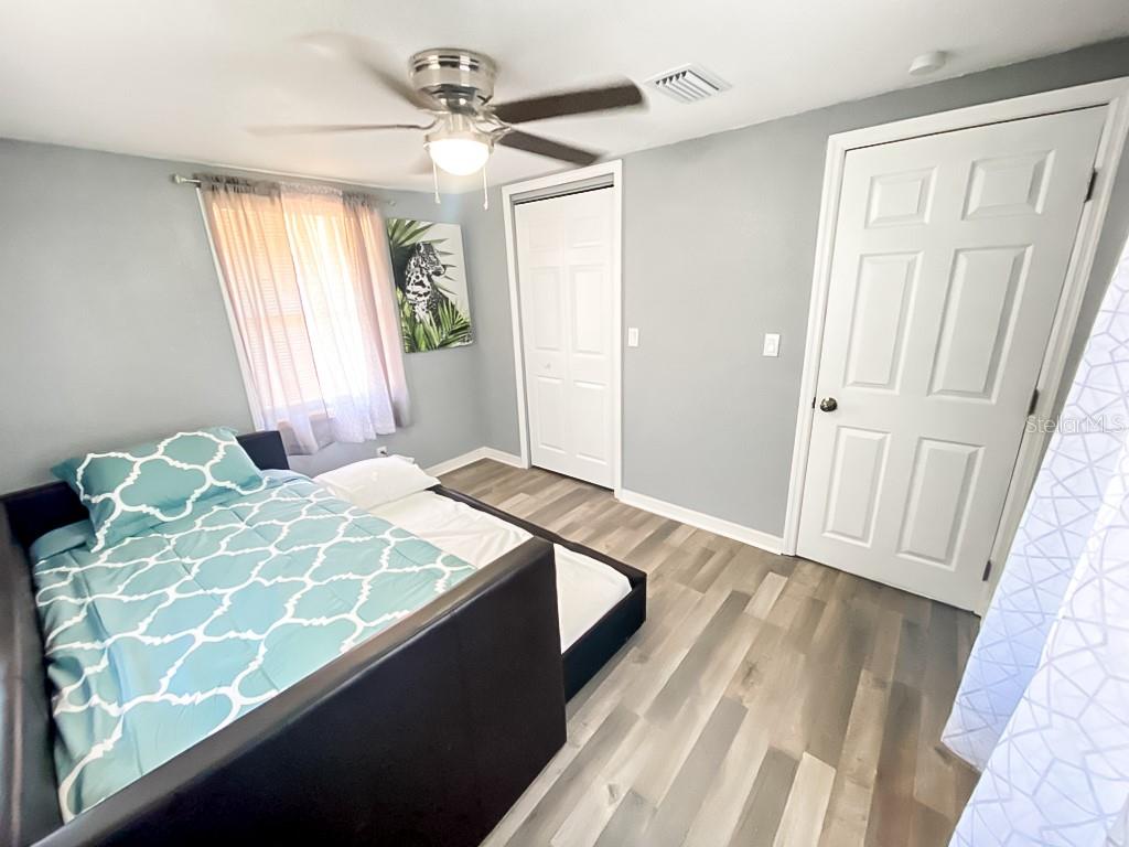 A bedroom features light gray walls, wood-look flooring, a ceiling fan, and a daybed — 4303 CHESTNUT AVENUE, SARASOTA, FL