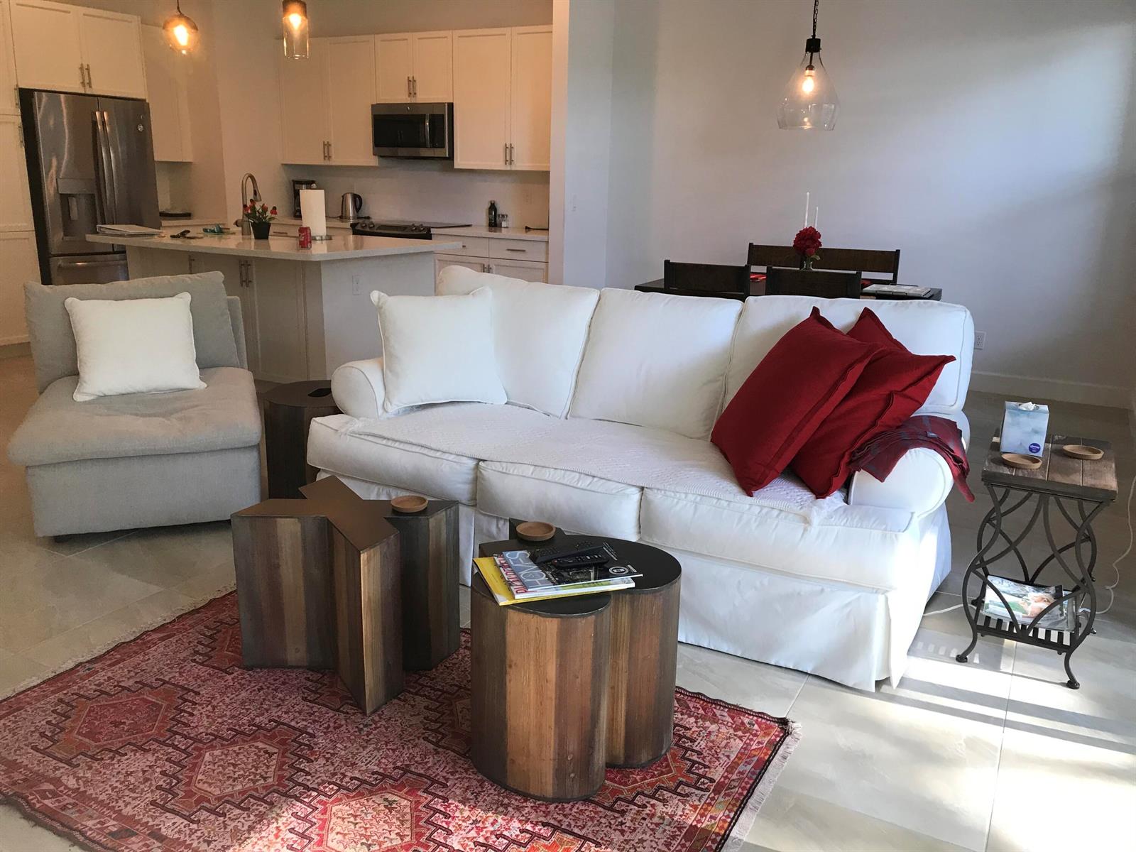 A living room with a white sofa, a patterned rug, and an open-concept kitchen — 23045 Clear Echo Drive # 76, Boca Raton FL 33433, BOCA RATON, FL