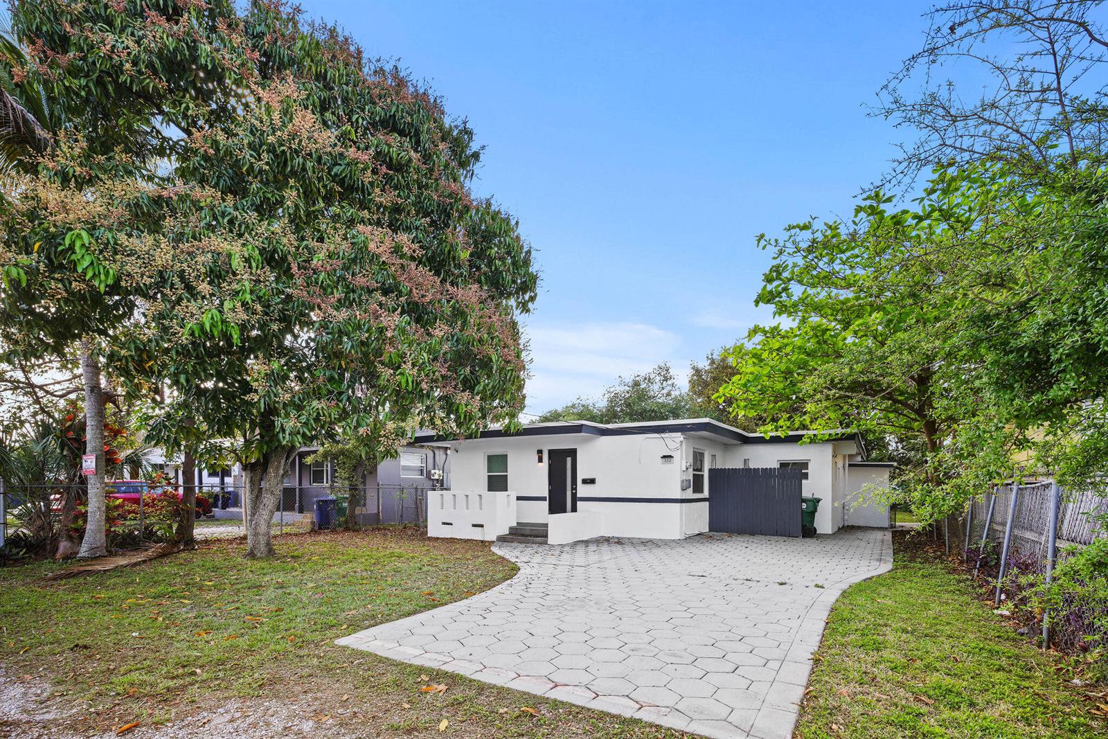 A white single-story house with a paved driveway and large trees in the front yard — 332 NW 97th Street, Miami FL 33150, MIAMI, FL