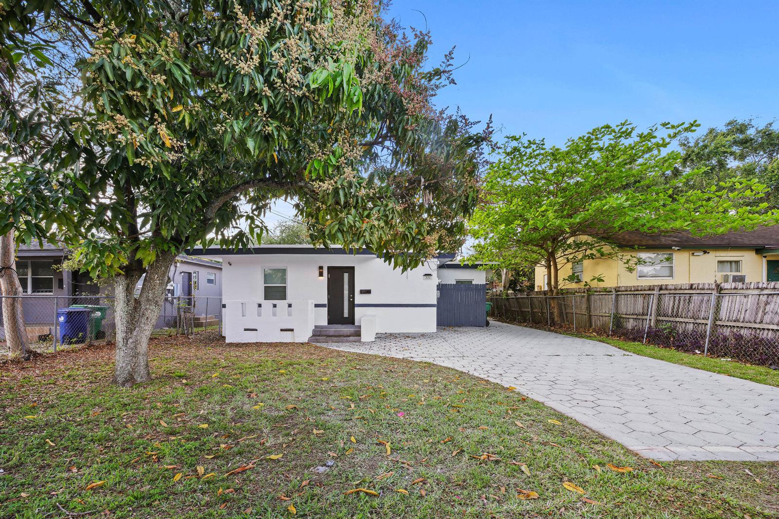 A white single-story house with a paved driveway and a large tree in the yard — 332 NW 97th Street, Miami FL 33150, MIAMI, FL