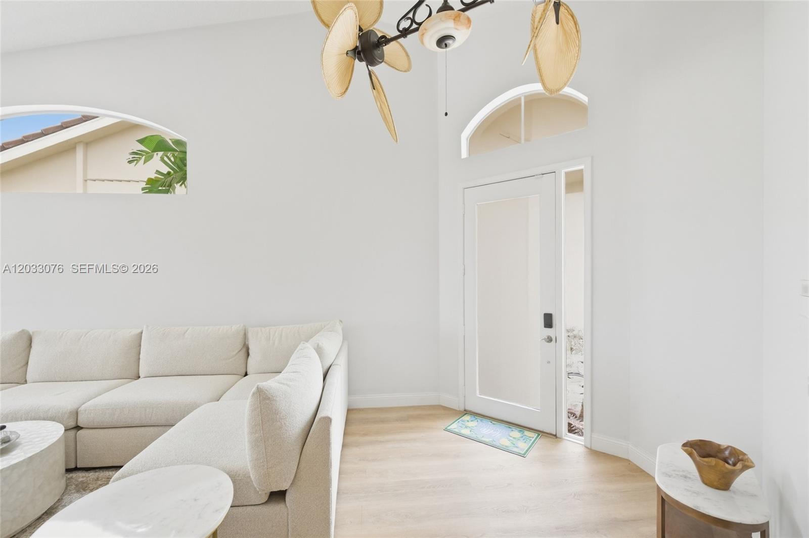 A bright living room features a white sectional sofa, light wood flooring, and a ceiling fan — 8141 Sandpiper Way, West Palm Beach FL 33412, WEST PALM BEACH, FL