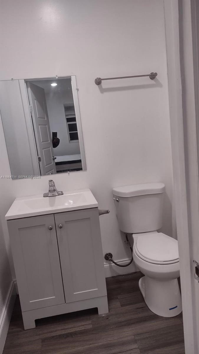 A small bathroom features a gray vanity with a white sink, a toilet, and a mirror — 13301 NW 31st Ave # 1, Opa-Locka FL 33054, OPA-LOCKA, FL