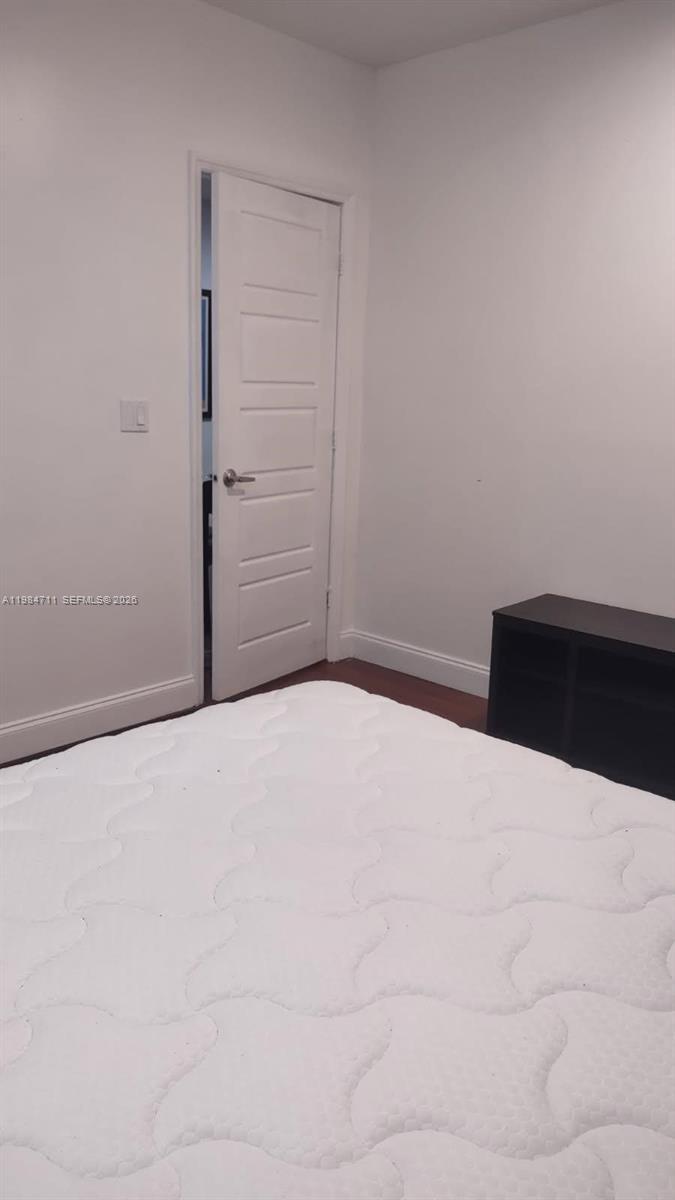 A bedroom features a white mattress, a dark storage unit, and a white interior door — 13301 NW 31st Ave # 1, Opa-Locka FL 33054, OPA-LOCKA, FL
